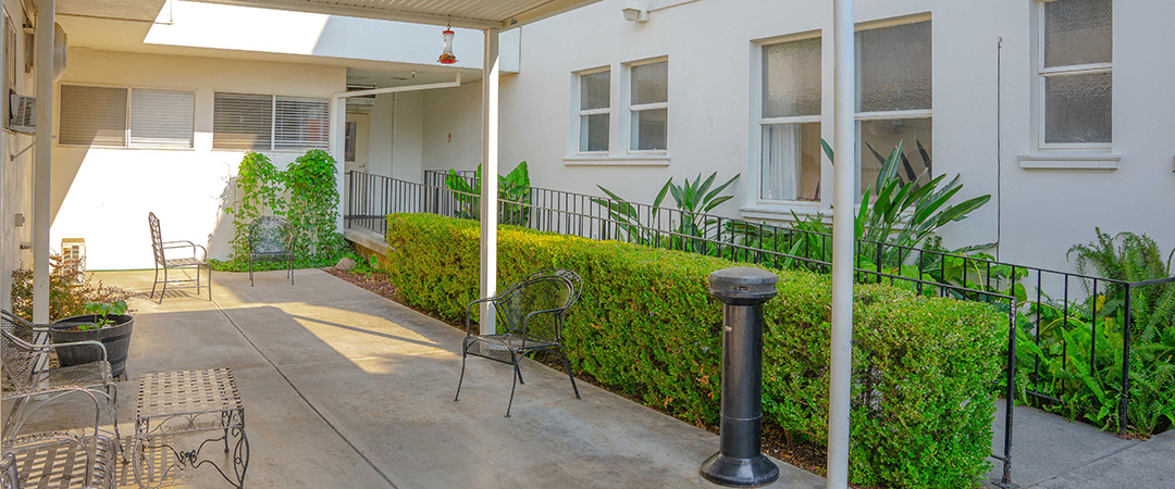 Shaded outdoor seating area at the Woodland Nursing and Rehab facility