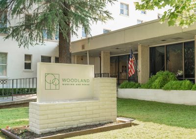 The front of the Woodland Nursing and Rehab facility showing the monument sign