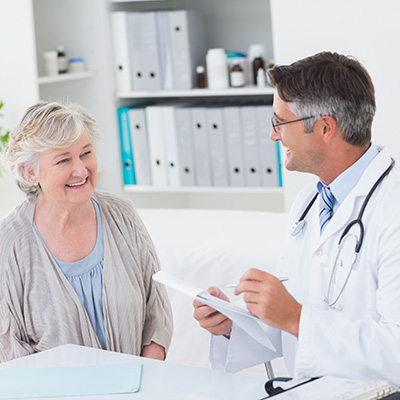 Doctor interviewing a patient and taking notes on a clipboard